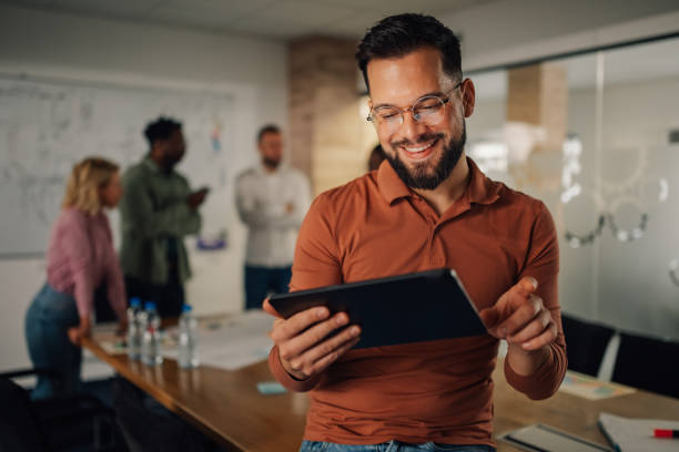 istock Smiling businessman using digital tablet during a meeting in the office 2198602301