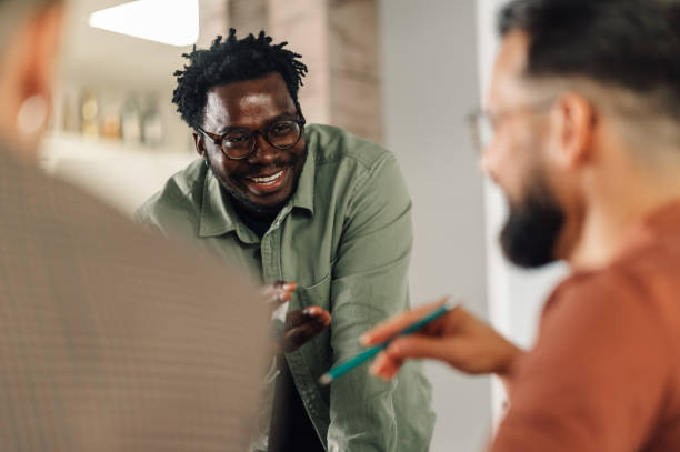 istock Smiling businessman leading a discussion with colleagues in a modern office 2198602329