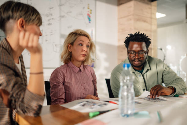 istock Marketing team reviewing documents during office meeting 2198602360