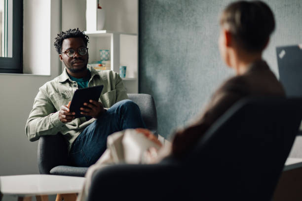 istock Patient showing information on digital tablet to doctor during therapy session 2198602373