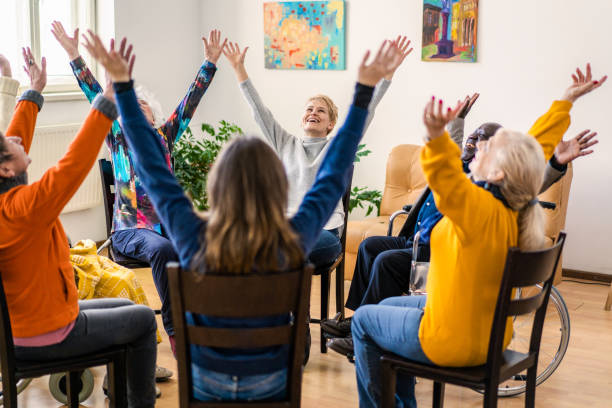 istock A mixed group with raised arms sitting in a circle 2198603571