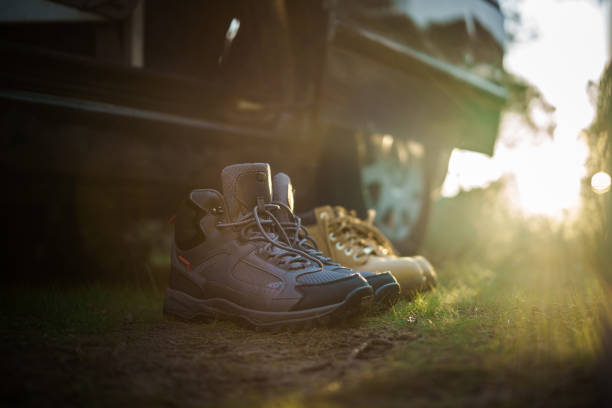 Boots of lonely tourist on lush grass covered mountains hill. Landscape photography