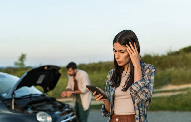 istock Couple having vehicle breakdown and using phone to call car insurance 2198603992
