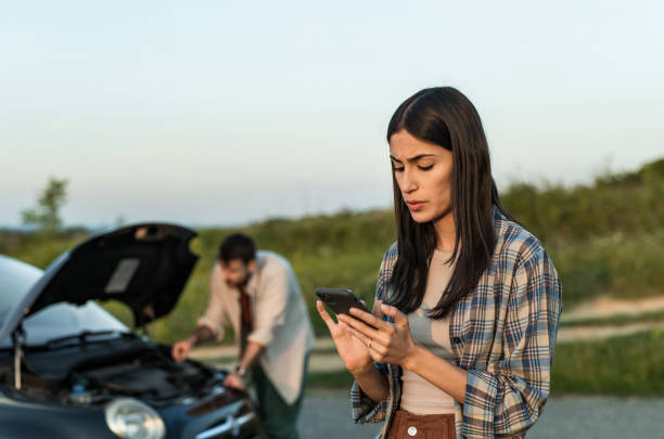 istock Couple having vehicle breakdown and using phone to call car insurance 2198604043
