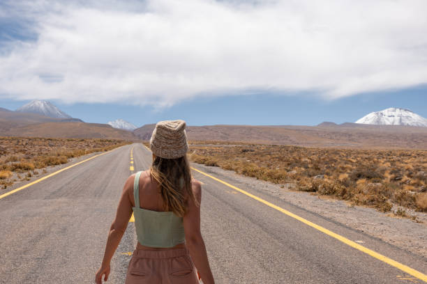istock Woman Walking on Desert Highway 2198604735