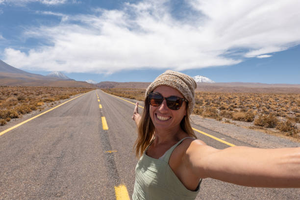 istock Woman Taking Selfie on Open Desert Highway 2198604739