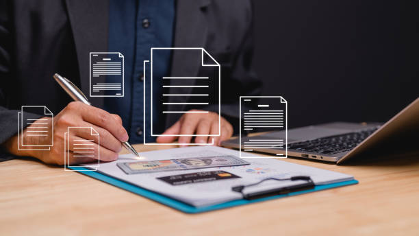 istock Businessman focuses on document preparation while surrounded by financial papers and laptop scene reflects professionalism, diligence, and importance of organized documentation in business 2198604843