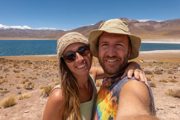 istock Couple Smiling in Desert Landscape with Lake View 2198604887