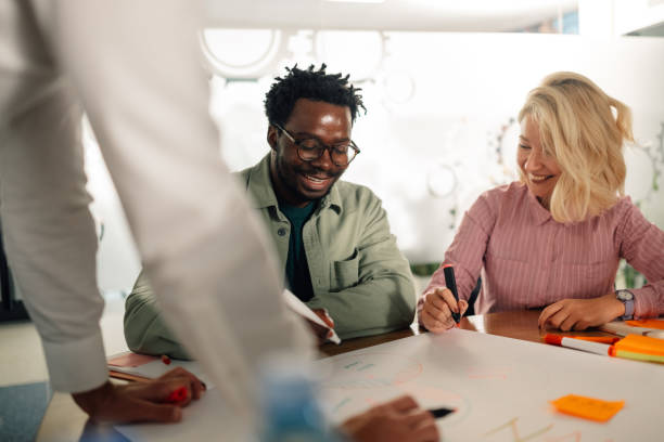 istock Marketing team working on a project, sharing ideas and smiling during a brainstorming session 2198605153