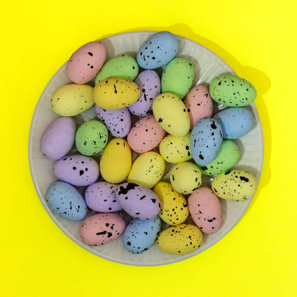 A plate of Easter eggs with different colors and sizes. The eggs are scattered all over the plate, creating a colorful and festive atmosphere