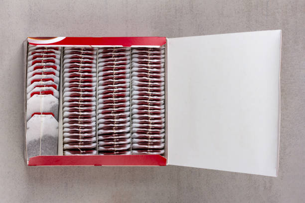 an open paper box with tea bags on a gray background top view with a copy space