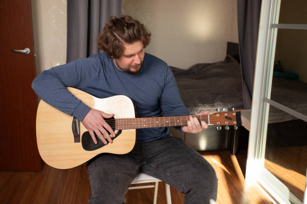 Man Practicing Acoustic Guitar, musician playing music, studying fretboard,