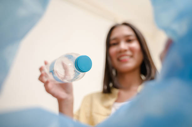 POV selective focus on used plastic water bottle dumping in to trash bin by housekeeper. Garbage recycle, plastic reuse house waste sorting for sustainable life concept.