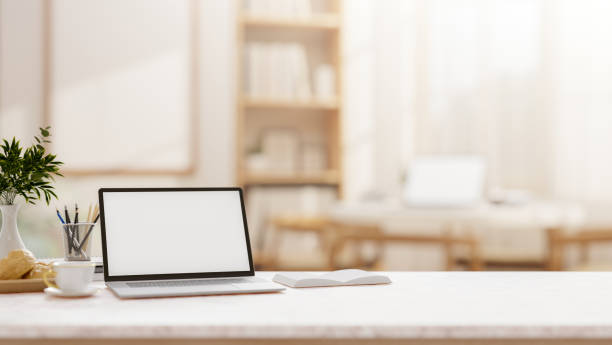 istock A laptop on a tabletop with a blurred background of a comfortable, minimalist room. 2198616505