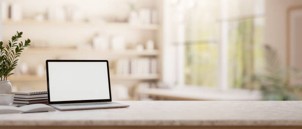 istock A laptop on a tabletop with blurred background of a minimalist room. 2198616516