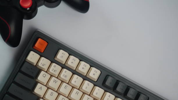 istock Mechanical Keyboard and Black Gamepad.  Low violet light. The concept of computer games, entertainment, gaming, leisure. Close view. 2198620628
