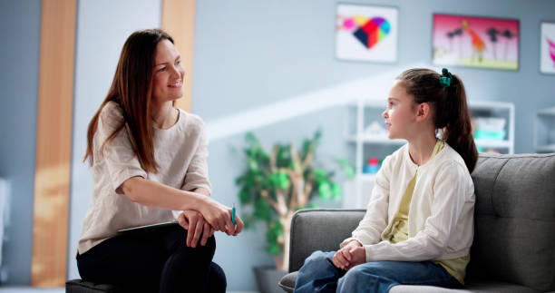 istock Young female child therapist comforts a depressed kid during counseling 2198632508