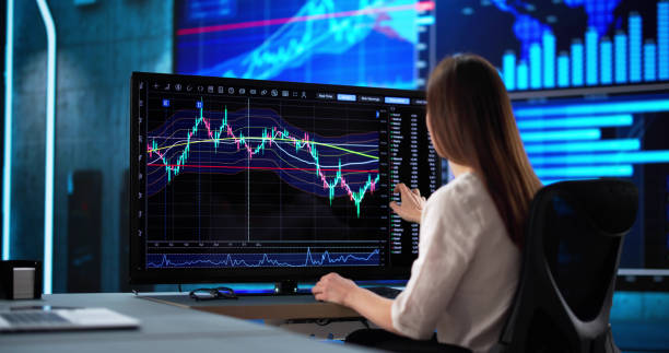 istock Professional woman analyzing stock market data on computer screens 2198632514