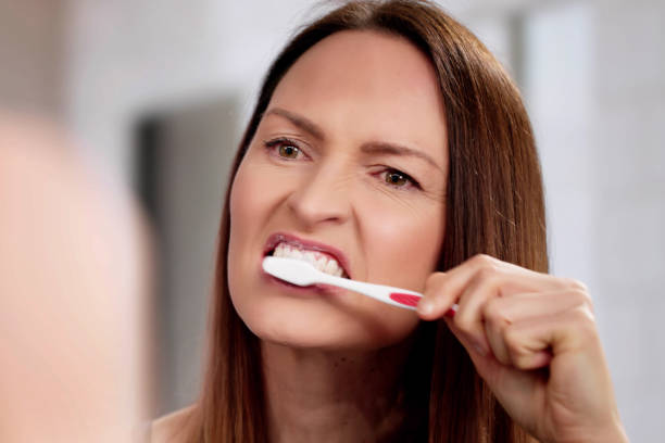 istock Woman meticulously brushes her teeth in morning routine 2198634028