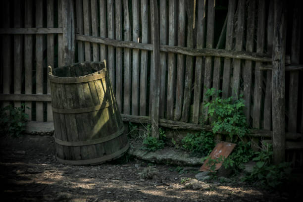 Old wooden barrel next to a wooden fence in the countryside