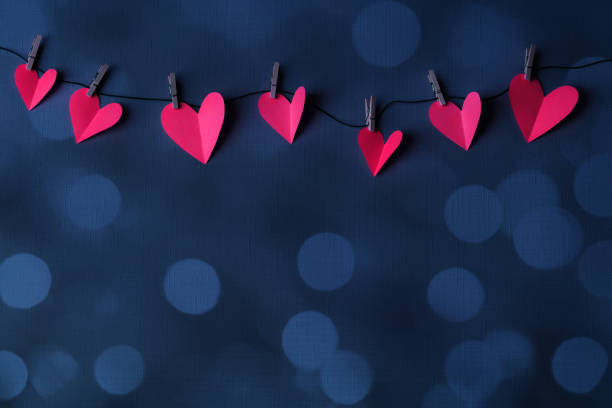 istock Paper hearts on a clothesline with bokeh lights and space for copy 2198636788