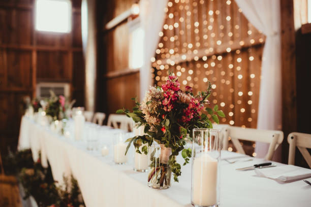 istock Head table inside of barn at wedding reception with flowers and string lights 2198637840
