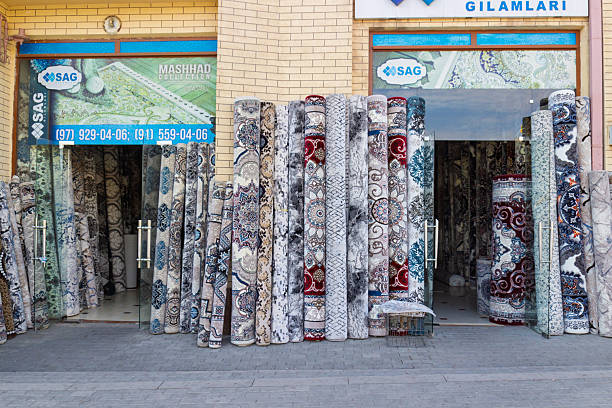 Samarkand, Uzbekistan - 2 October 2024: Open glass doors to modern carpet, rug and carpet runner shops in a non-tourist area of Samarkand, Uzbekistan. Carpets are displayed on the street near store