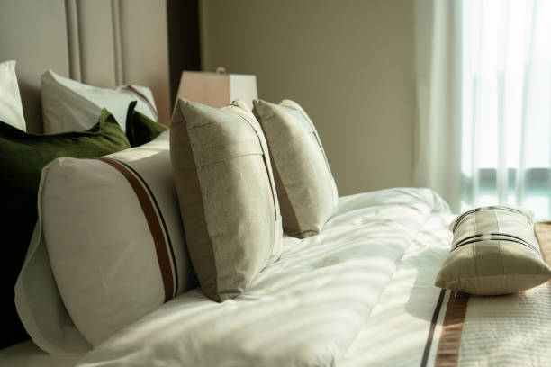 istock Cozy bedroom with decorative pillows and soft sunlight 2198642952