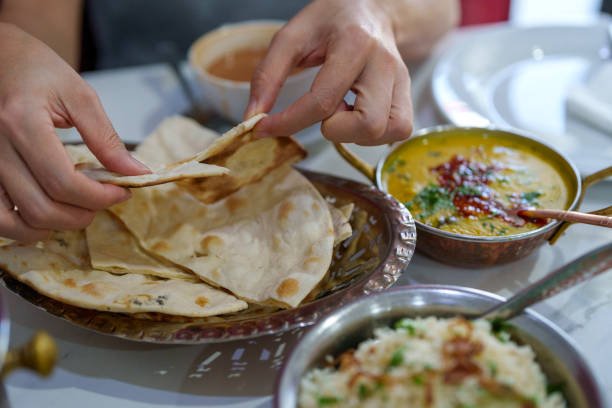 istock Tearing Freshly Baked Naan with Dal Tadka 2198643710