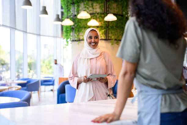 istock Woman wearing hijab approaching service counter in cafe 2198643980