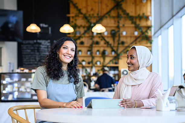 istock Diverse female entrepreneurs discussing ideas while seated at cafe table 2198644014