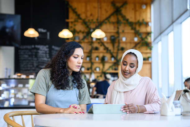 istock Cafe owner sitting with financial adviser looking at digital tablet 2198644017