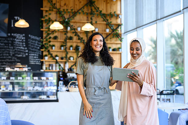 istock Diverse women entrepreneurs smiling and using a digital tablet in a cafe 2198644046