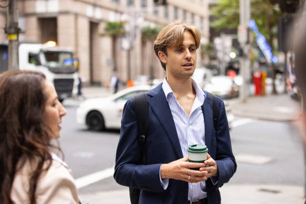 Professionals Engaging in Conversation on a Cityside Walkway