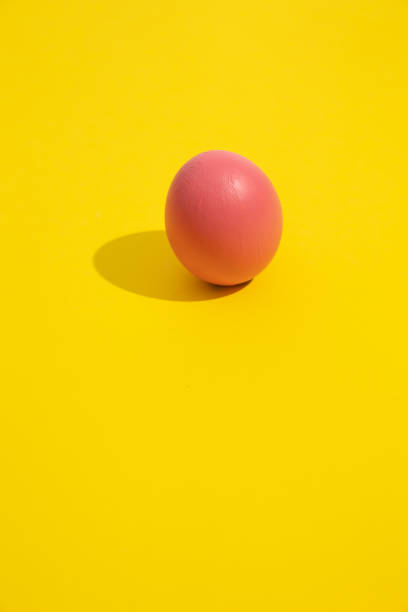 istock Minimalist vertical image of a pink egg on a yellow background 2198645382