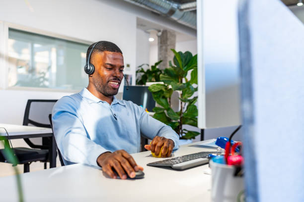 istock Smiling young man working with headset in coworking office 2198646077