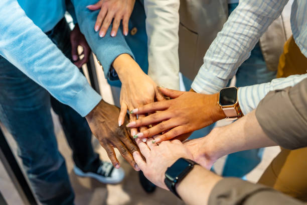 istock Coworkers joining hands in a circle, showing unity and teamwork 2198646170