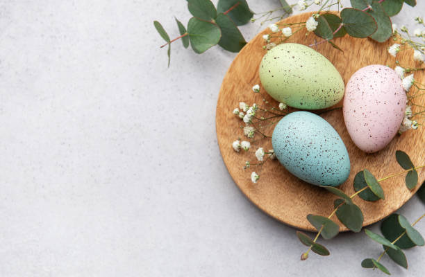 istock Pastel easter eggs on wooden plate with eucalyptus 2198647393