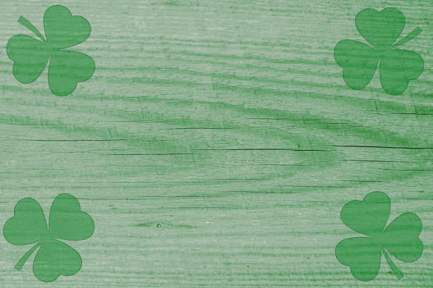 istock St Patricks day background. Shamrocks over a light green wood background. 2198647799