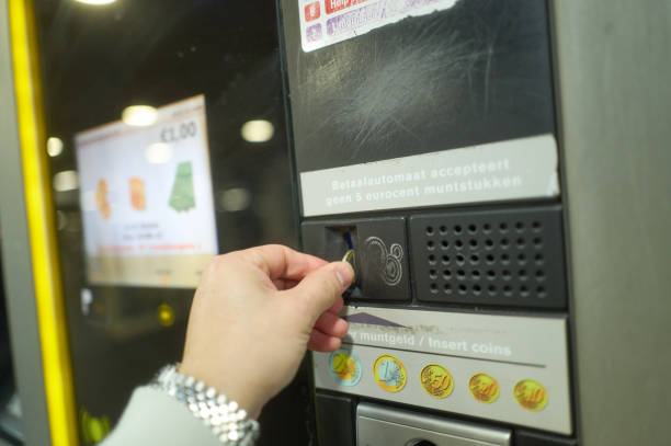 Businessman inserting coin into a vending machine in amsterdam