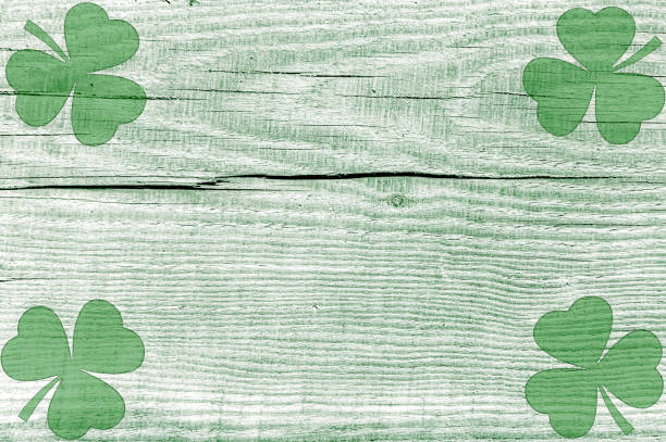 istock St Patricks day background. Shamrocks over a light green wood background. 2198647861
