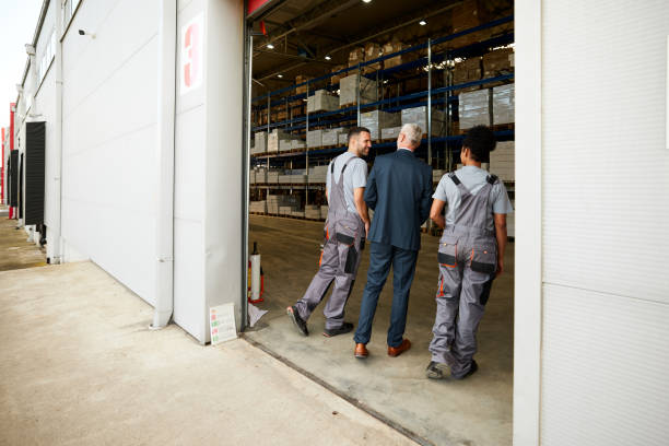 istock Back view of senior inspector talking to workers while entering the storage room. 2198647971