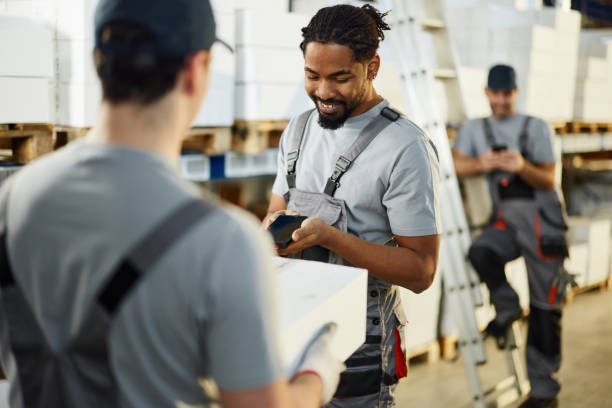 istock Manual workers scanning QR code of a package in storage room. 2198648090