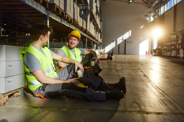 istock Happy manual workers talking on a break in distribution warehouse. 2198648573