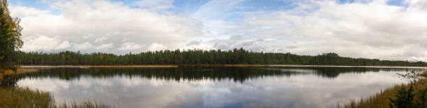 istock Tranquil Lake Reflecting Expansive Sky and Dense Evergreen Forest in Remote Wilderness During Autumn Season 2198648648