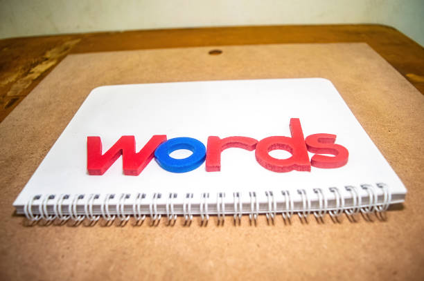 Colorful wooden letters spelling words on a spiral bound notebook, showcasing creativity and education. Ideal for educational and creative projects