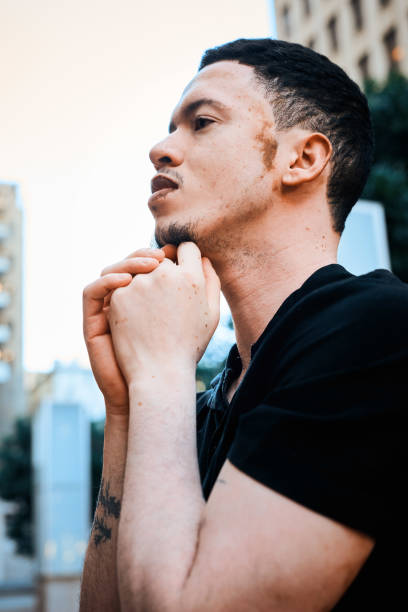 istock Contemplative Man with Vitiligo Reflecting in Urban Cityscape 2198650190