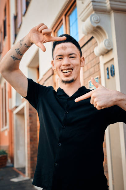 Man smiling and making peace sign gesture on urban street