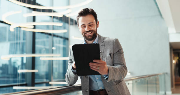 istock Office, lobby and businessman with tablet for feedback, schedule information or conference hall planning. Seminar, employee and keynote speaker with smile for networking, research and online review 2198654771