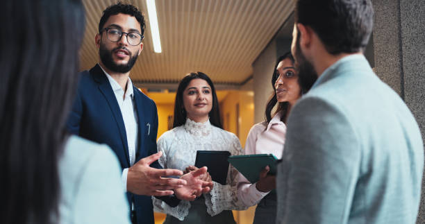 istock Discussion, project or business people in lobby for feedback or schedule update in conference hall. Teamwork, employees or keynote speaker with staff in office for networking, seminar or event review 2198654879